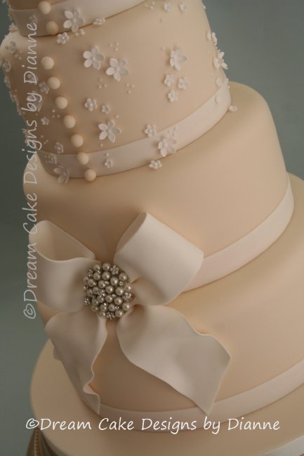 4 Tier Ivory Wedding Cake with sugar bow, delicate blossoms and diamante and pearl brooch - Dream Cake Designs (Dianne Stanley)