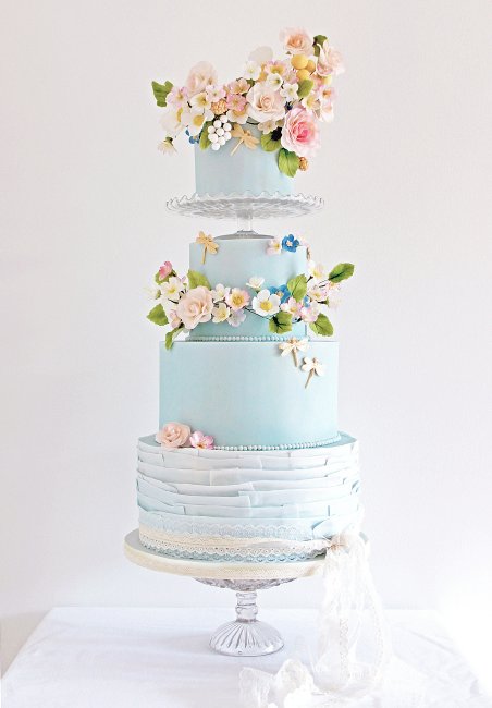 Bohemian Romance, a crown of sugar flowers on this pale blue and ruffle wedding cake. - Cobi & Coco Cakes