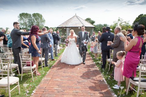 One of our happy couples walking down the aisle from their civil ceremony in our outside Ceremony room. - All Manor of Events