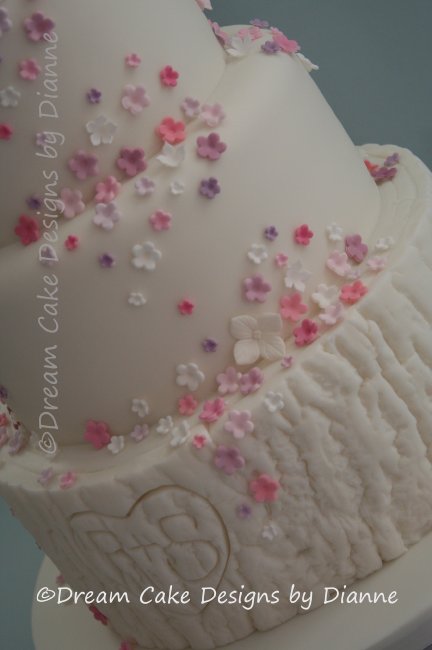 4 Tier White Wedding Cake with pink lovebirds and shades of pink and purple blossoms finished with a log style lower tier with carved heart and initials - Dream Cake Designs (Dianne Stanley)