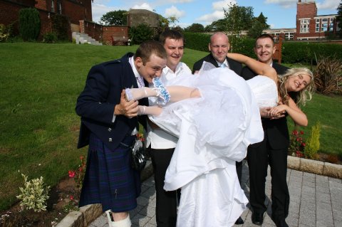 Groom removing his wife's garter - with a little help from his friends - Hi Tec Weddings