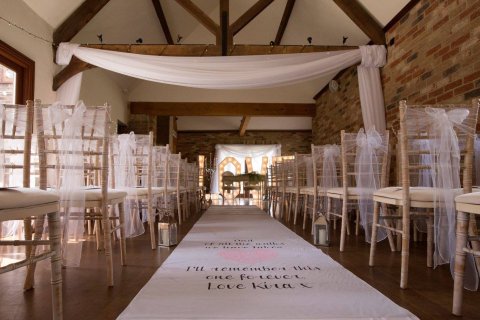 We dress both reception and ceremony rooms, here is an example of our ceremony room draping, organza chair sashes and a personalised aisle runner we supplied for this bride. - To Have & To Hire Events Ltd