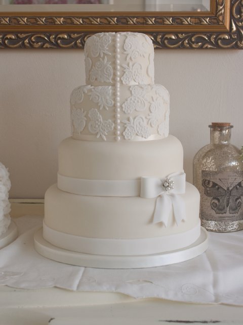 Vintage style four tier wedding cake with lace detail and sugar paste bow - Rebecca Gilmore Wedding Cakes