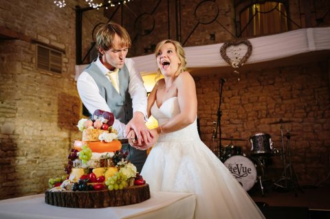 Bride and groom cutting tthe cake at The Great Tythe Barn - Ketch 22 photography