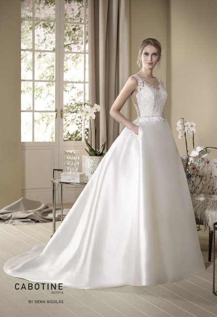 Mikado wedding dress. Semi-sheer bodice embellished with a lace overly and bateau neckline. Princess skirt with pleated back and side pockets. - GN DESIGN GROUP