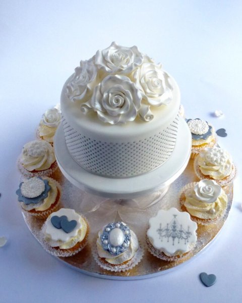 Moon River. nspired by the twentieth century style icon Audrey Hepburn, this timeless classic wedding cupcake tower will be an elegant centre piece for any wedding reception and YES all of those dots on the top tier cake are hand piped, promise, no fibs! The cupcakes add that extra bit of glamour with a mixture of hand crafted brooches and soft sugar roses and there are ample cupcakes to fill the stand so you can use the extra ones to add some pretty confetti additions to your cake table - Karen's Cakes 