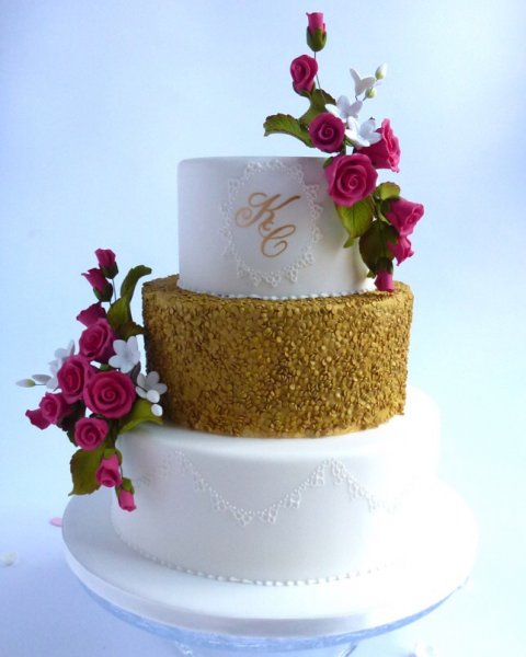 Wonderful Tonight. Edible sequins, delicate hand piped lace and 2 beautiful sprays of sugar flowers all make for a stunning and contemporary wedding cake but add the Bride and Groom initials on the top tier makes it truly unique!! The sequins and monograms can be in various metallic effect finishes and there are also various choices of colours and types of flowers. - Karen's Cakes 