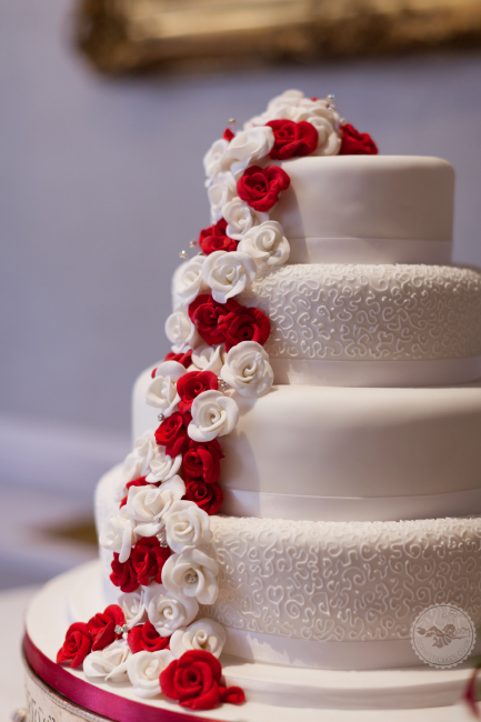 Small sugar roses trail down the cake to make stunning display. - Sophisticakes 