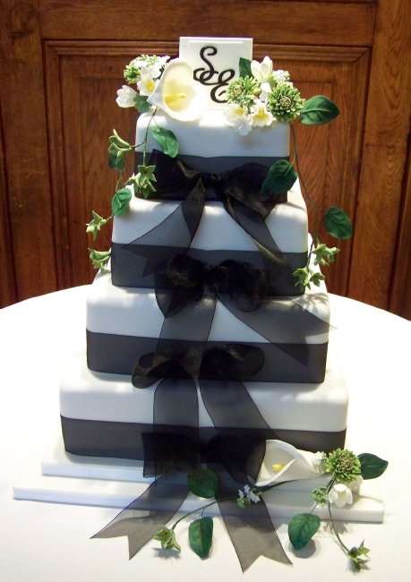 "Bow Ties" wedding cake with initialed sugar plaque and sugar flowers matching the brides bouquet. - The Incredible Cake Company