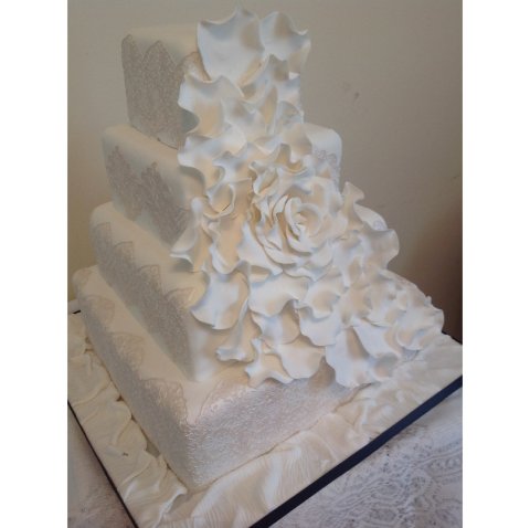 Four tier square with edible lace and cascading sugar petals - Cakes Unlimited of Yorkshire