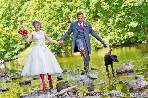 Bride & Groom walking dog in river. - Dave Cropper Photography