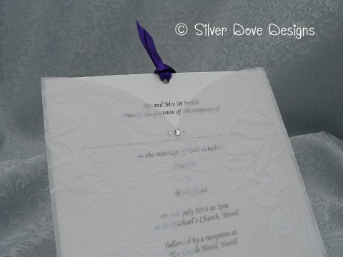 Promise - a beautiful vellum pocket covered with a floral pattern, accented with diamantes. Inside the pocket is the invitation card itself finished with a double satin ribbon in the colour of your choice. - Silver Dove Wedding Stationery