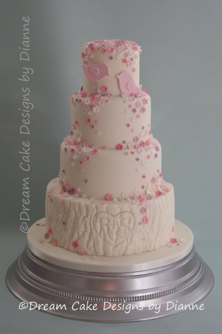 4 Tier White Wedding Cake with pink lovebirds and shades of pink and purple blossoms finished with a log style lower tier - Dream Cake Designs (Dianne Stanley)
