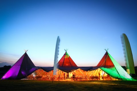 A Tipi lit by our lighting technician - My Festival Wedding