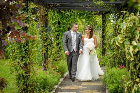 Our beautiful flower filled pergola acts as an aisle for outdoor weddings - High House Weddings