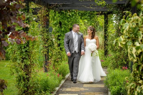 Our beautiful flower filled pergola acts as an aisle for outdoor weddings - High House Weddings