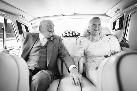 A more mature bride and groom laughing in wedding car - Ketch 22 photography